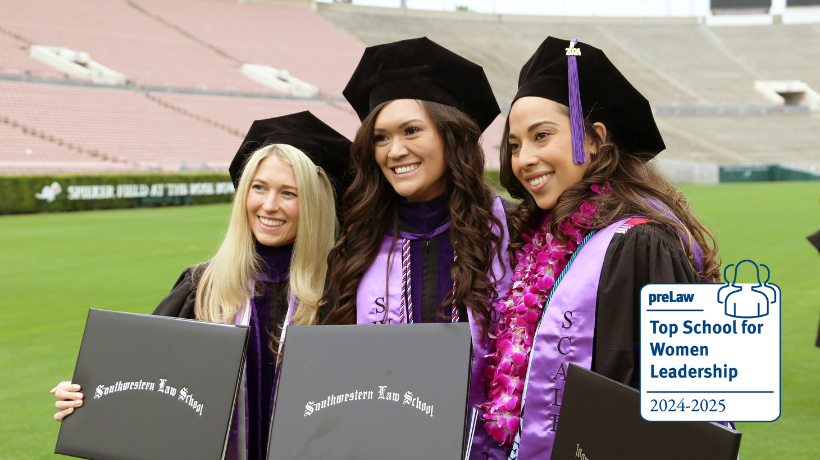 Three female students in commencement robes smiling with their diplomas with the Top School for Women Leadership preLaw badge on bottom right hand corner